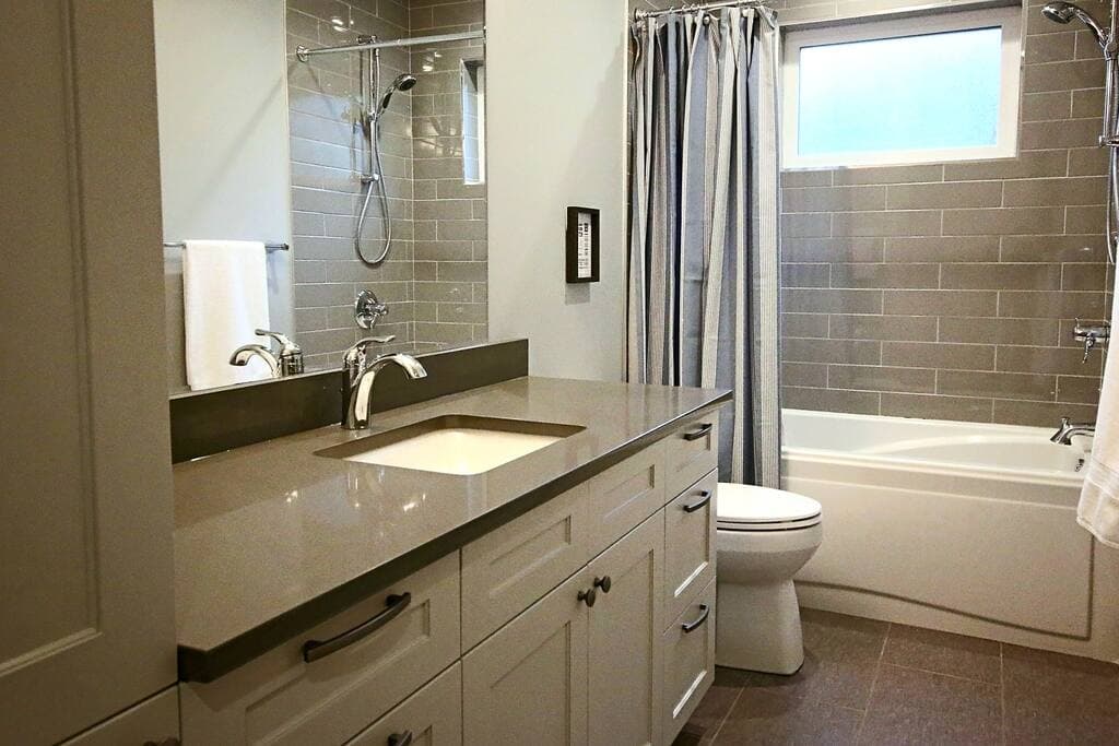 Second-floor bathroom with tub, tiled shower surround and long vanity