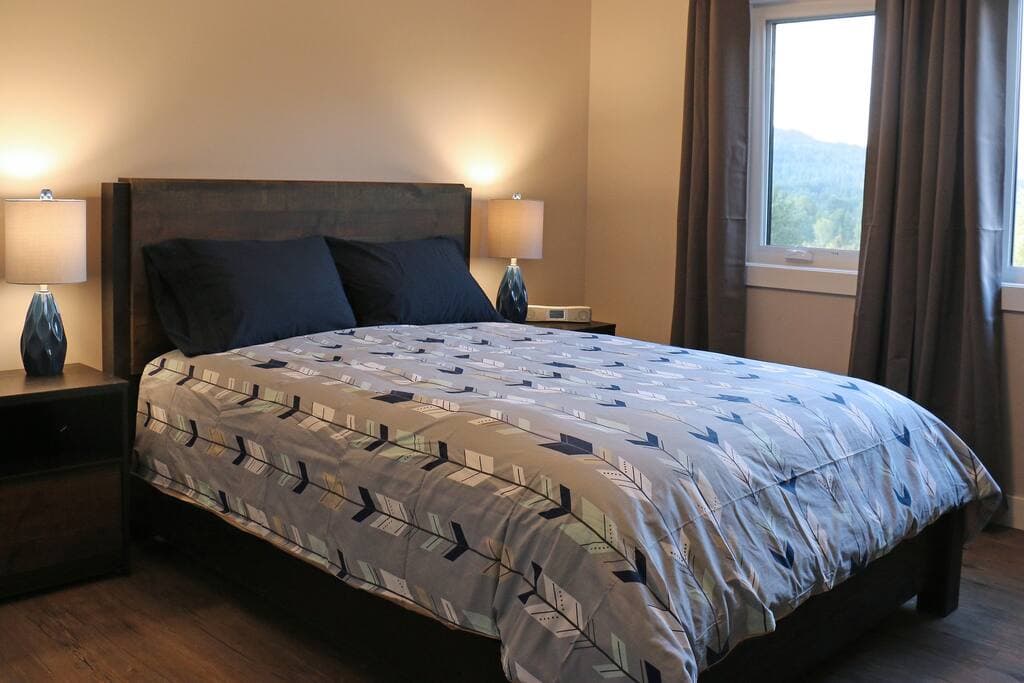 Second-floor queen bedroom with matching bedside lamps and a mountain view out the window