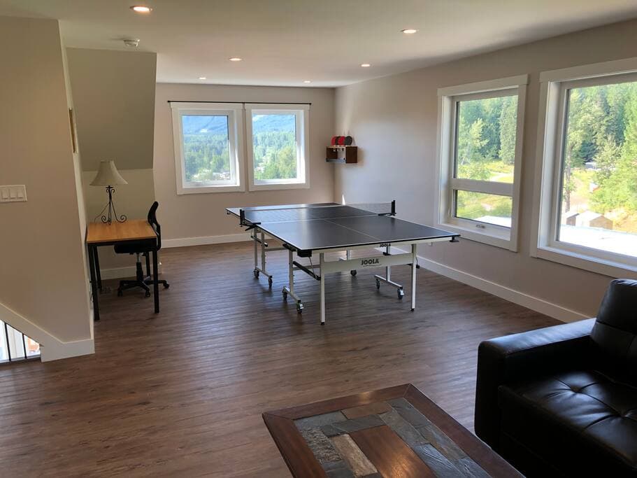 Second-floor games loft with table tennis table, desk and mountain views from windows on two sides