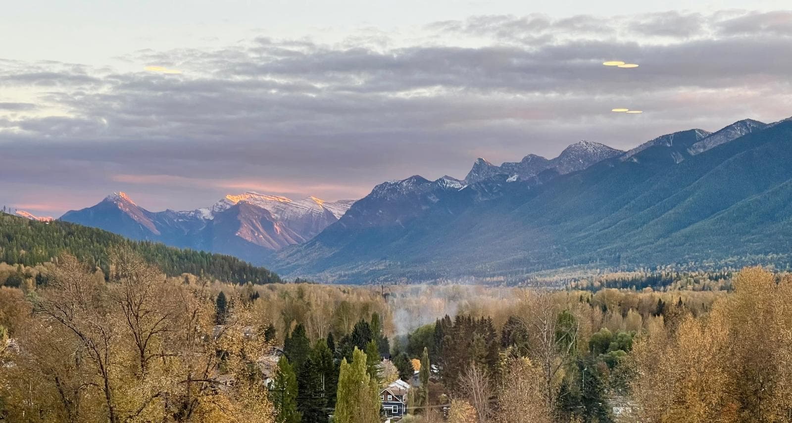 Autumn view from the deck: golden cottonwoods filling the Elk Valley beneath snow-dusted peaks at first light